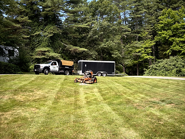 Landscaping truck and mower parked on a freshly cut lawn