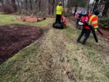 Landscape crew mowing and blowing a residential property