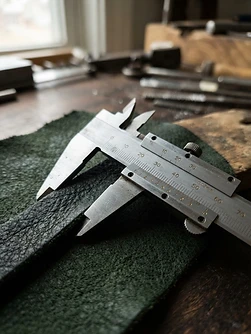 Precision measuring caliper over a leather swatch