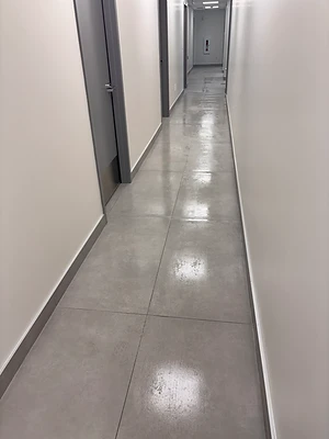 Long corridor au plancher de carreaux gris pendant l’entretien.