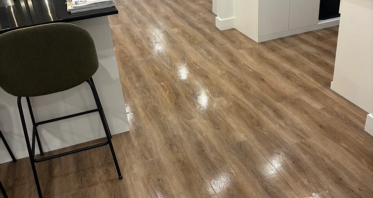 Plancher en cours de nettoyage près de postes de travail et d’une cuisinette.