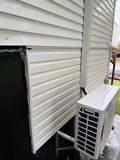 Revêtement extérieur d’une résidence après le nettoyage, près de la thermopompe.