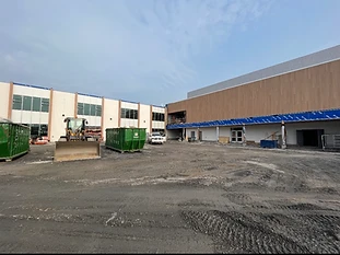 Vue extérieure d’un bâtiment et de ses abords pendant les travaux de construction.