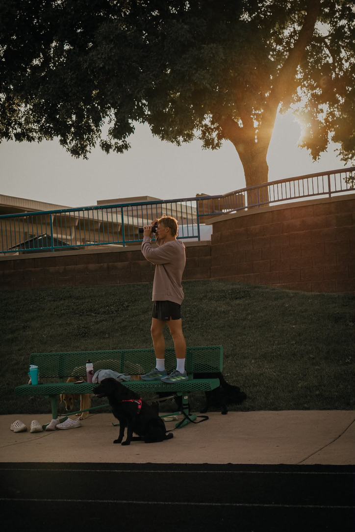 Conor Wherry standing on a bench, shooting with his camera