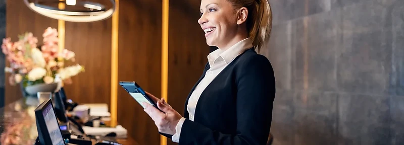 Hotel front desk team member working with guests at the reception desk