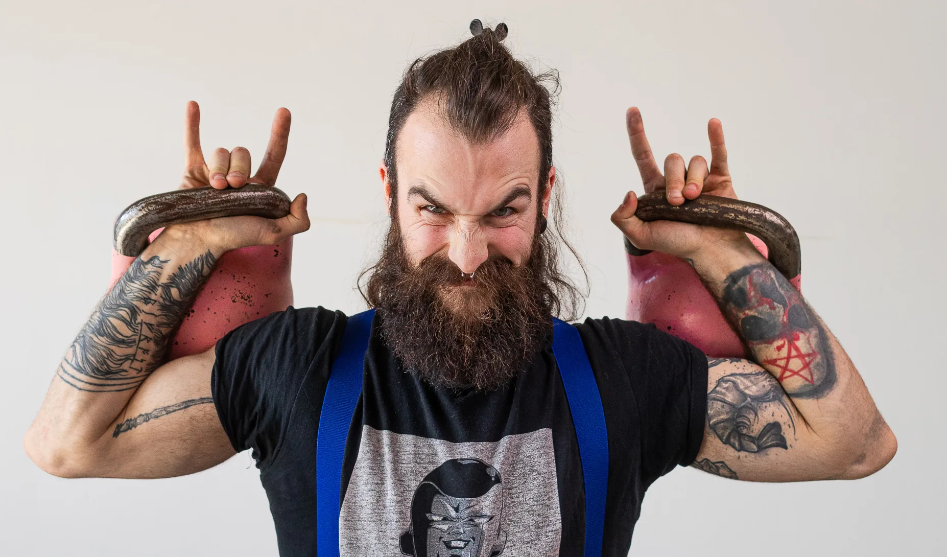 Athlète en développé avec deux kettlebells roses au studio The Roar Style