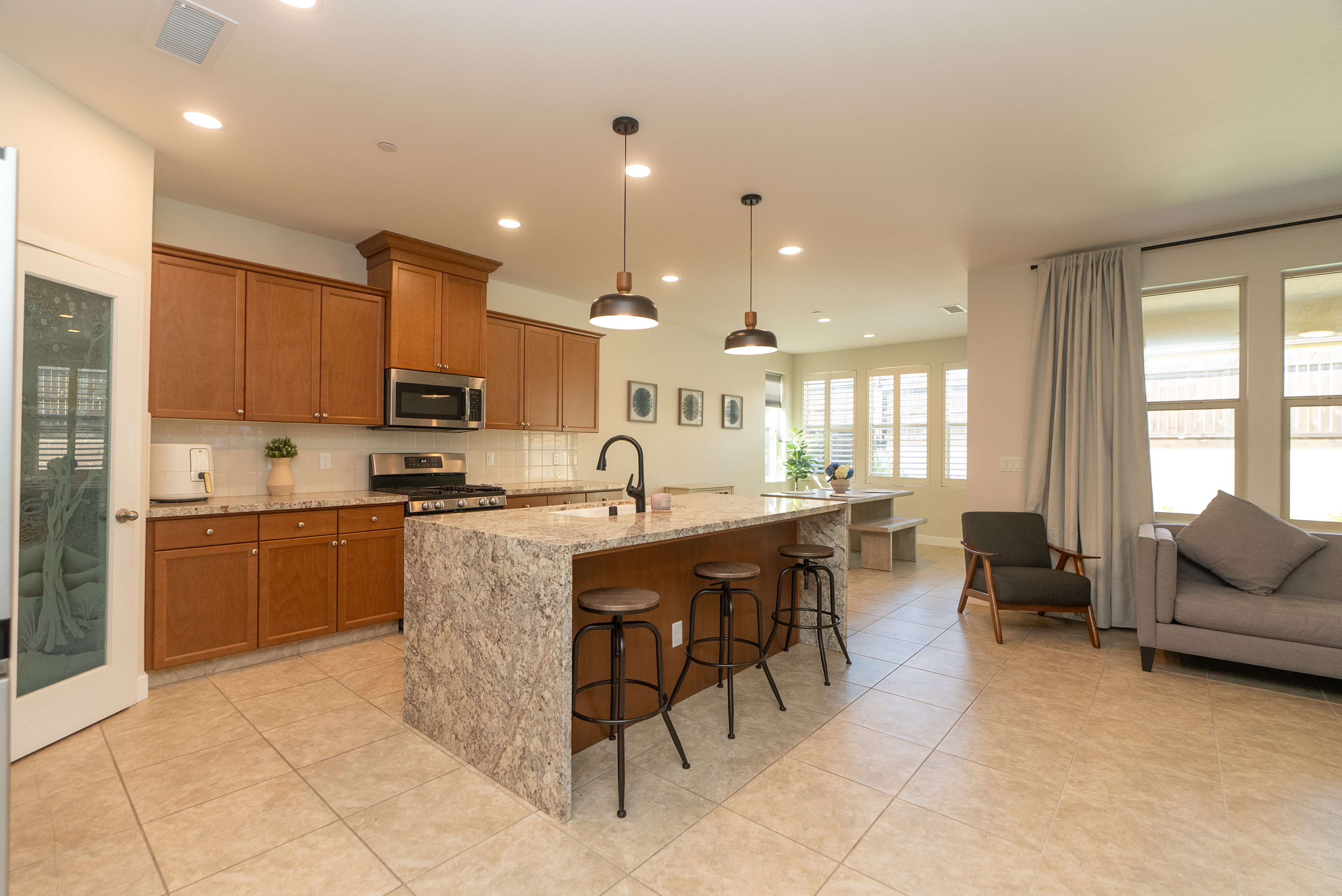 Modern open-plan kitchen with waterfall island and matte black pendant lights
