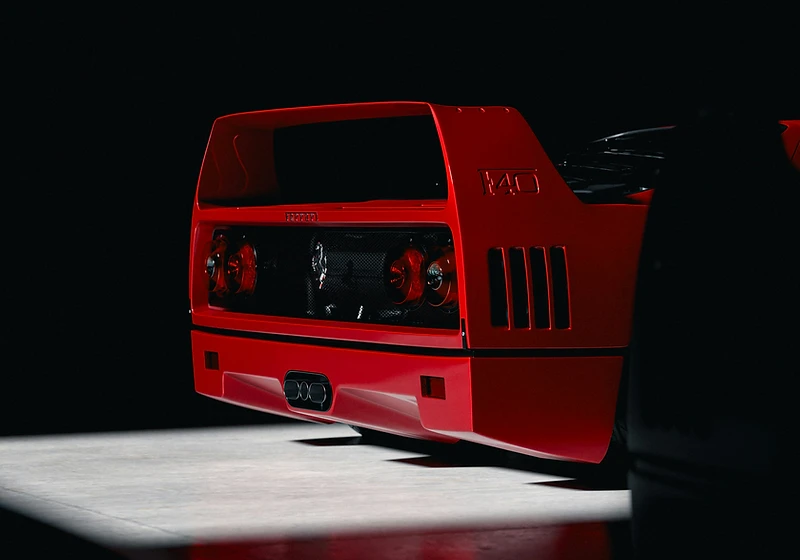 The rear of a Ferrari F40, photographed against a black studio backdrop.