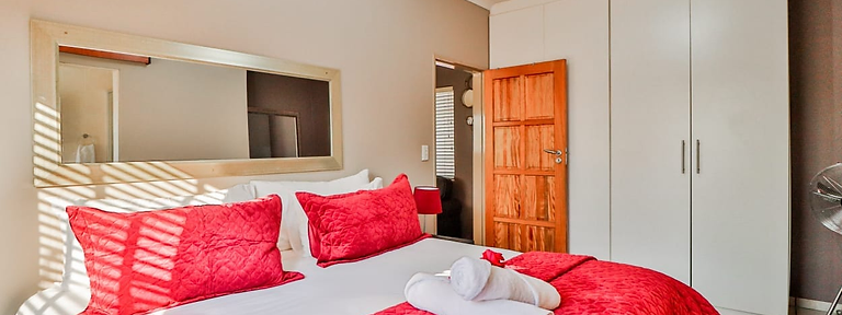 F Block bedroom with king-size bed at Rudman Townhouses