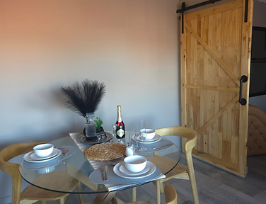 Intimate dining setting with a complimentary bottle of JC Le Roux in the Love Nest at Rudman Townhouses