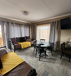 Living and dining area in a Rudman Townhouses self-catering unit