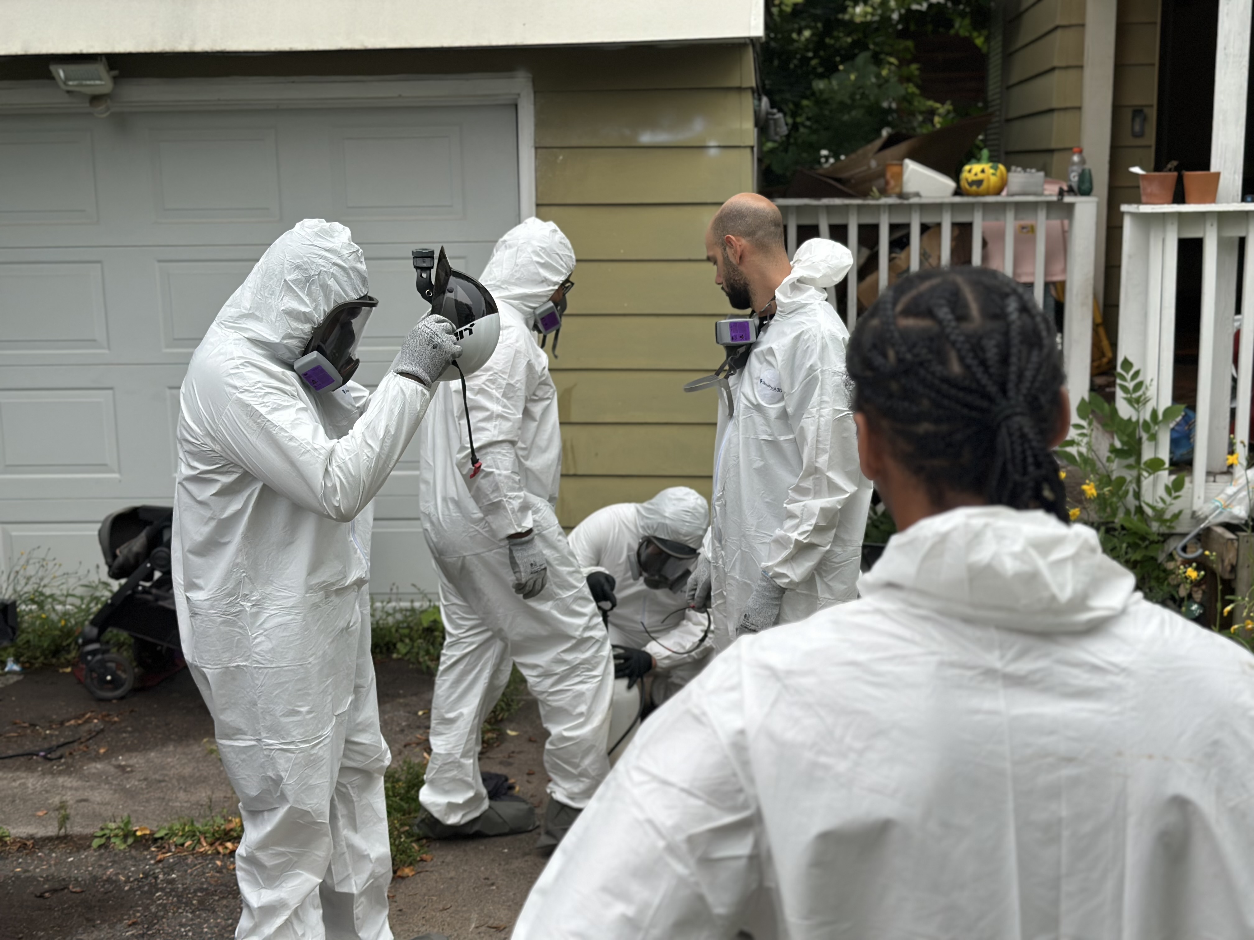 Abatement crew working outside a residence in full protective suits