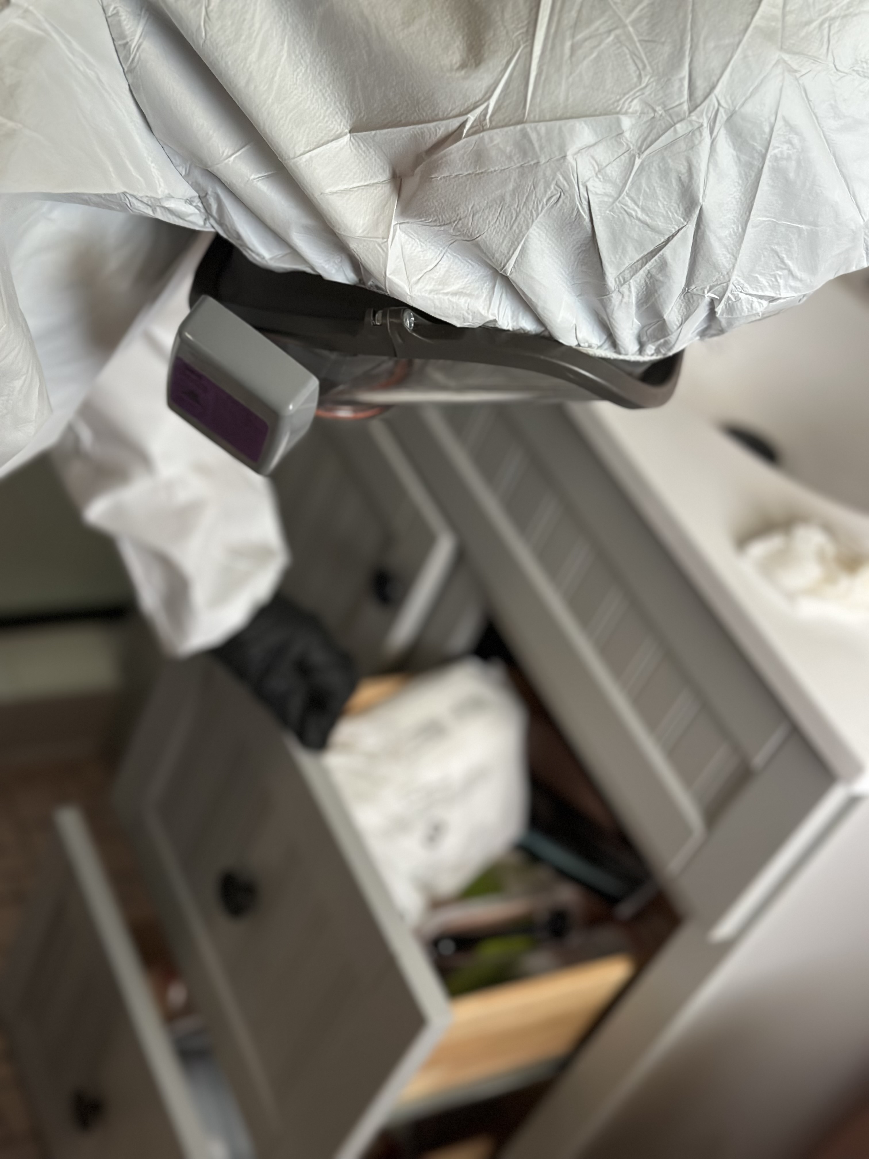 Worker reaching into a bathroom vanity during containment work