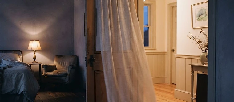 A softly lit doorway between two rooms