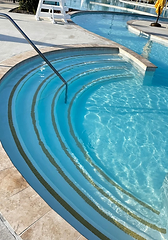 Curved pool entry steps beneath clear water