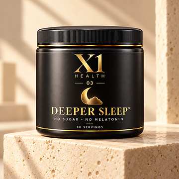 X1 Health Deeper Sleep black and gold tub resting on a cream travertine stone block in soft natural light