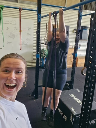 Supported gym session with pull-up bands and cheering