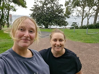 Two friends smiling on a walk by the water