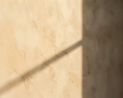 Warm sunlight falling on a textured plaster wall