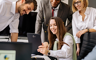 A diverse team collaborating around a tablet in a bright modern office.