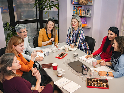 A group of professionals collaborating around a meeting table in a modern, naturally lit office.