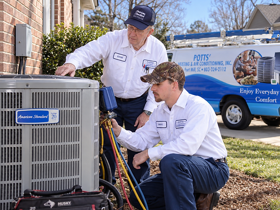 Potts' technician with refrigerant gauges on an American Standard air conditioner