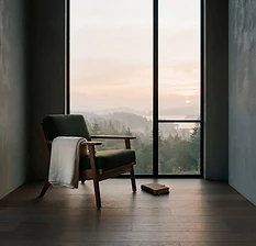 An empty chair beside a sunrise window suggests the quiet isolation leaders can feel