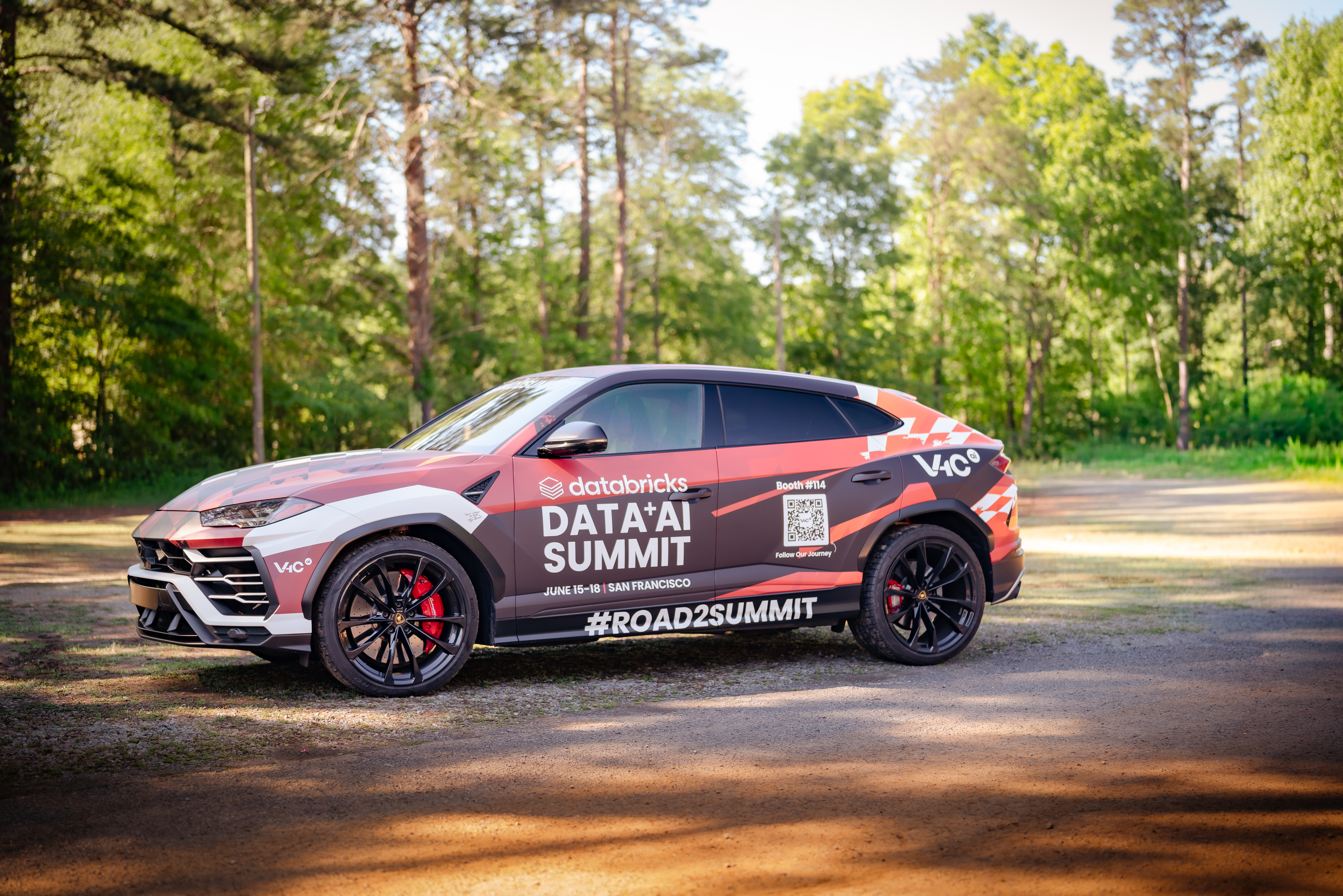 The fully wrapped Road2Summit Lamborghini Urus parked on a forest gravel path