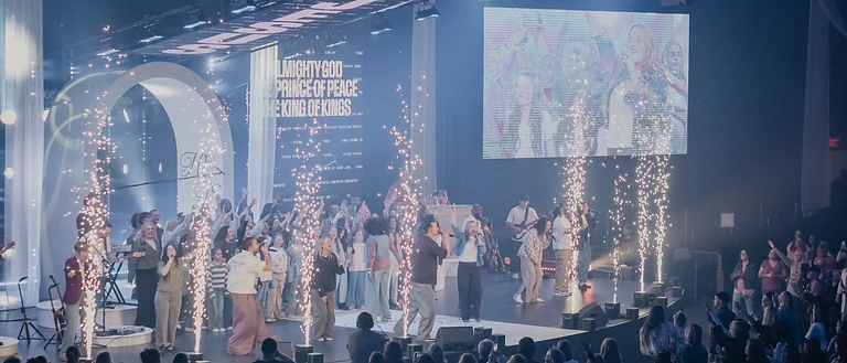Worship team and choir on the Devoted stage with spark fountains