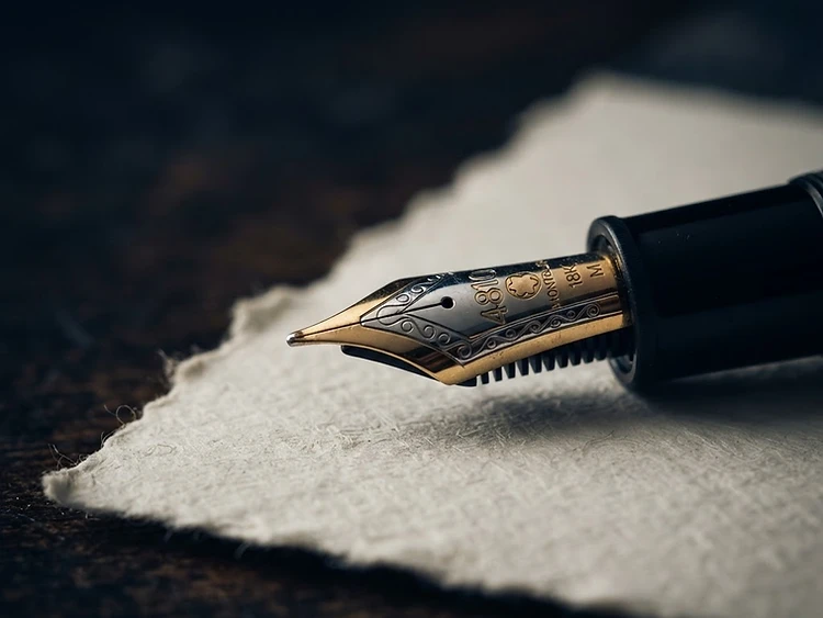Fountain pen nib resting on heavy legal paper