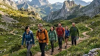 Grupo diverso de personas caminando alegremente por un sendero de montaña en España