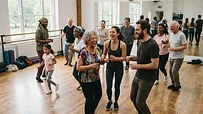 Grupo de personas sonriendo y bailando en un estudio de danza amplio y luminoso