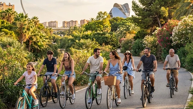 Grupo de amigos montando en bicicleta por el Jardín del Turia en Valencia con luz de atardecer.
