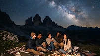 Grupo de personas observando el cielo nocturno estrellado en un campo abierto
