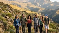 Grupo de personas diversas caminando por una ruta de senderismo en la montaña