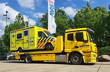 Een ambulance van RAV Hollands Midden op de bergingsplaat van de wagen van Betten Sneek in Leiden