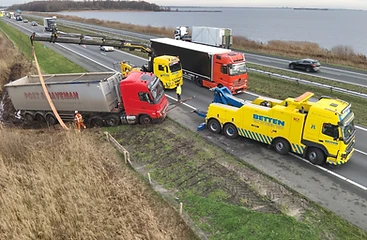 Bergingsactie langs de weg: Betten takelt een vrachtwagen met oplegger uit de berm