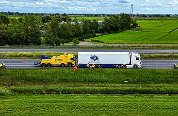 Hulpverlening aan een vastgelopen oplegger langs de snelweg, hoog gezien vanuit de lucht