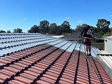 Professional roof cleaning in progress on tiled roof