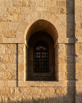 צילום אווירה: קיר אבן ירושלמית עם חלון מקושת באור אחר הצהריים