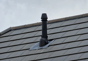 Lead flashing around a vent pipe on a tiled roof