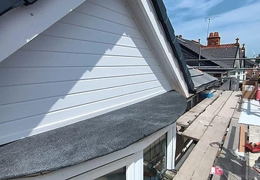Refelted bay window roof with white cladding and dark ridge