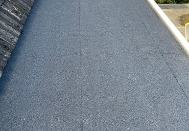 Flat roof covered in new grey roofing felt