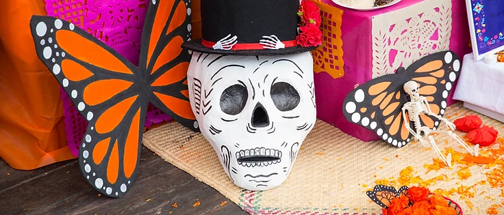 Ofrenda con maschera a forma di teschio, cappello a cilindro e fiori di cempasúchil durante il Día de los Muertos Roma 2025.