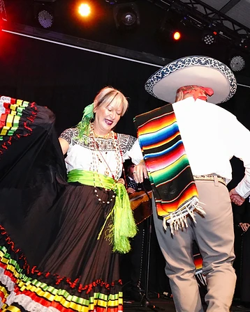 Coppia di danzatori in abiti tradizionali messicani sul palco con musicisti, durante il Día de los Muertos Roma.
