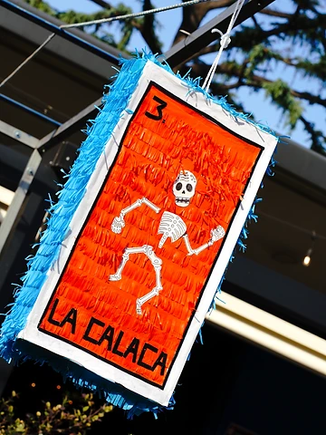 Piñata a forma di carta della Loteria durante il Día de los Muertos Roma 2024.