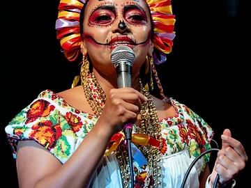 Cantante con abito tradizionale ricamato durante il Día de los Muertos Roma 2023.