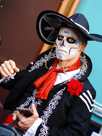 Uomo in costume da Catrín con sombrero ricamato e trucco scheletrico, durante l'edizione 2022 del Día de los Muertos Roma.