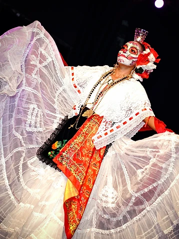 Danzatrice con trucco da Catrina, gonna di pizzo bianco e scialle rosso ricamato, sul palco durante l'edizione 2023 del Día de los Muertos Roma.