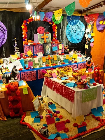 L'ofrenda illuminata la sera, piena di foto e bigliettini